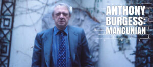 Anthony Burgess standing in front of a wall in Manchester