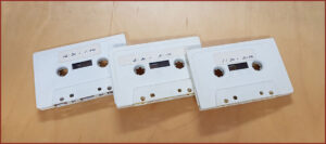 Three cassette tapes on sparse background
