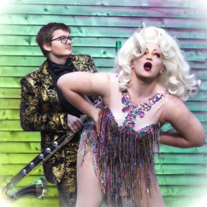 Jamie Redman and Robyn Saunders posing in front of a multi-coloured brick wall